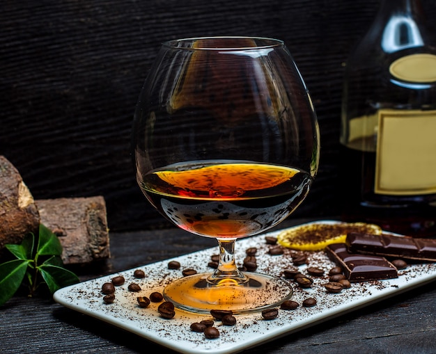 Glass of cognac and chocolate bars