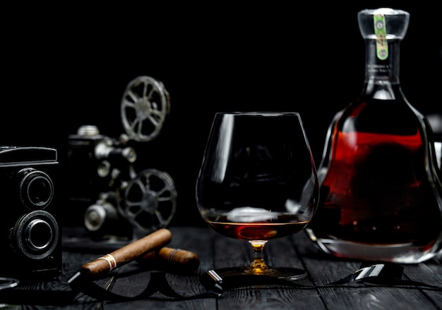 Glass of cognac and cigar on a wooden table