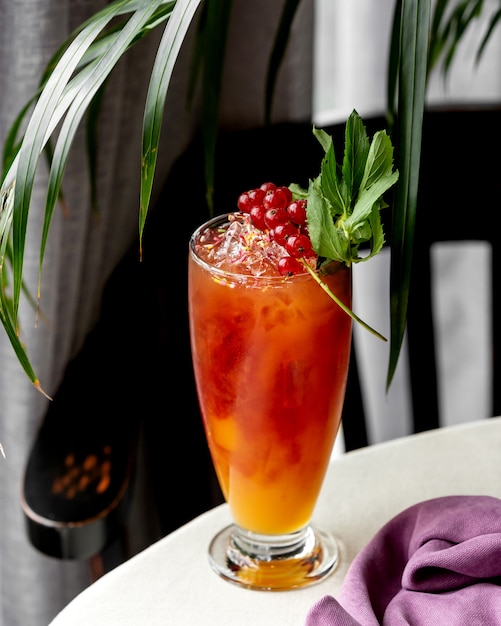 Free photo glass of cold cocktail garnished with redcurrant