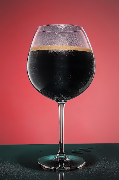 Glass of cold frothy dark beer on an old wooden table