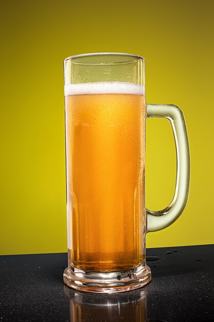 Glass of cold frothy lager beer on an old wooden table