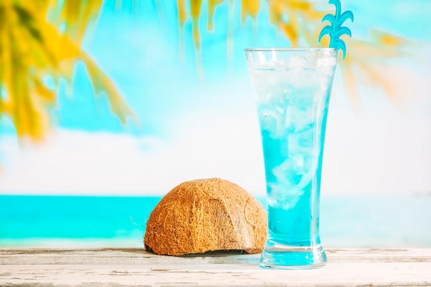 冷たい青い飲み物と反転ココナッツの殻のガラス