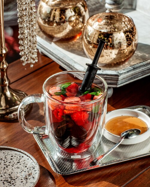 glass cup of berry cocktail with strawberry raspberry and mint