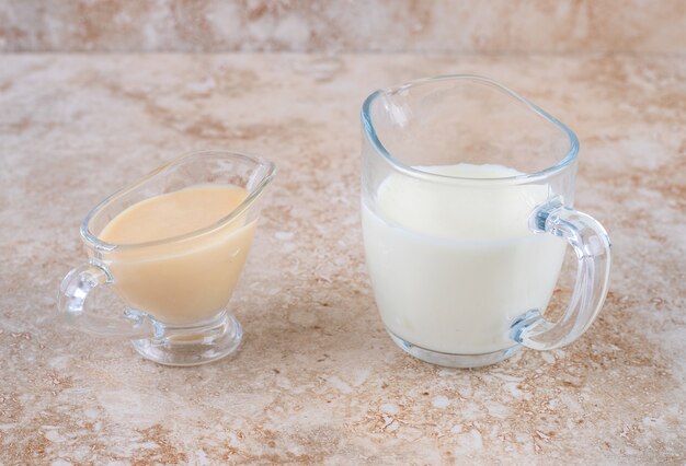 Стеклянная чашка холодного вкусного молока на мраморной поверхности