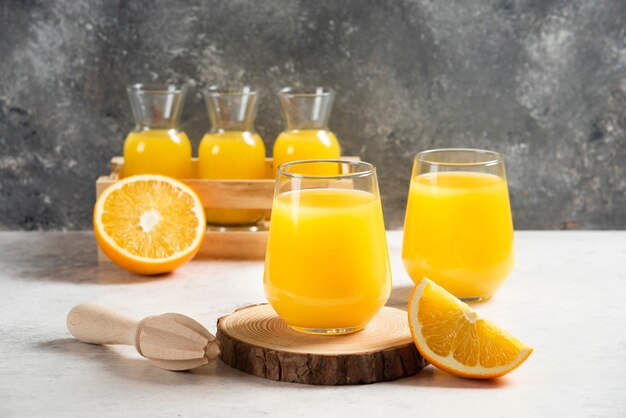 A glass cup of fresh juice with sliced orange.