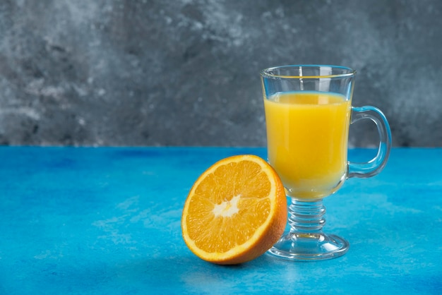 オレンジのスライスとジュースのガラスカップ。