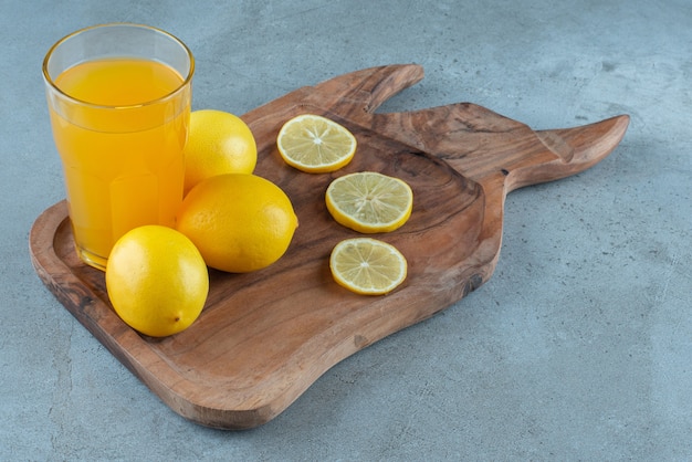 Free photo a glass cup of orange juice with fresh lemons .