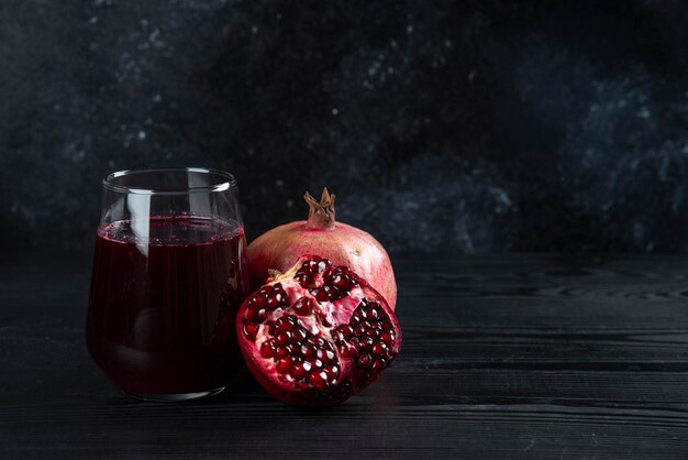 A glass cup of pomegranate juice on dark. 