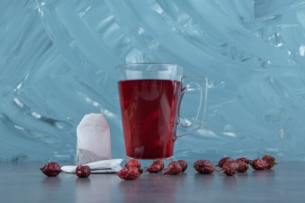 A glass cup of rosehip tea on marble.