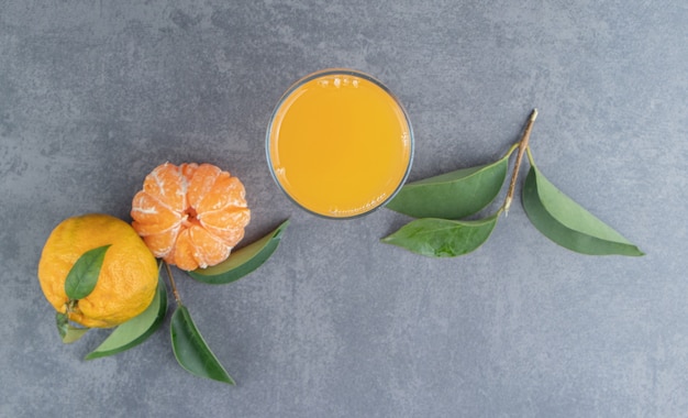 A glass cup of tangerine juice with leaves 