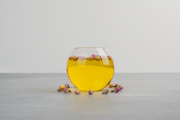 Glass cup of tea on grey table.