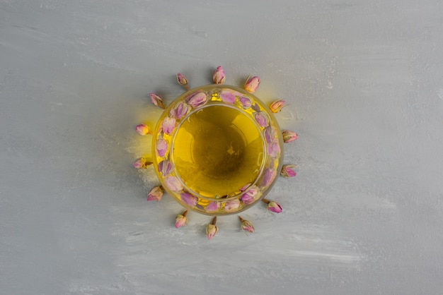 Glass cup of tea on grey table.