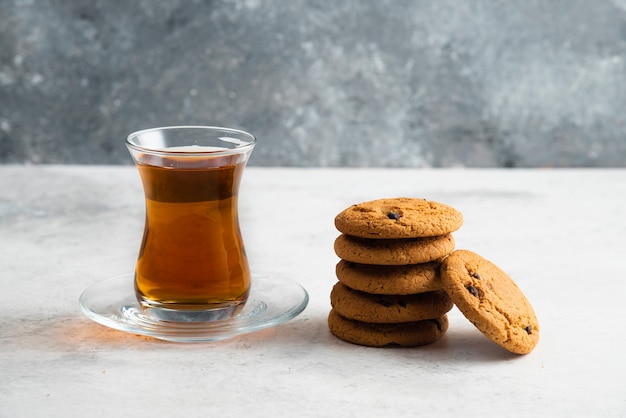 Free photo a glass cup of tea with delicious cookies .