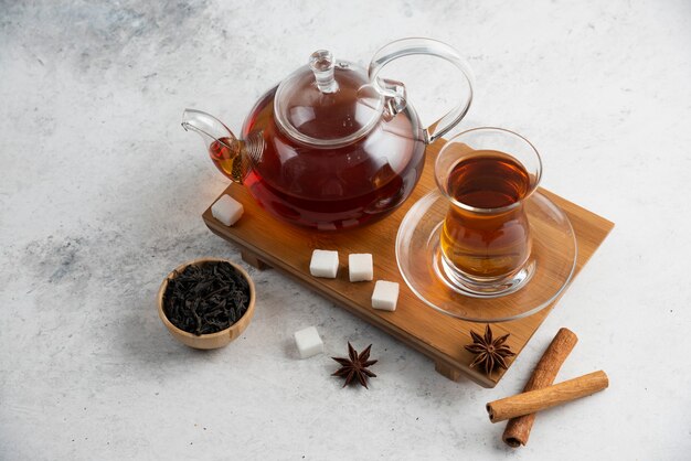 A glass cup of tea with sugar and star anise.