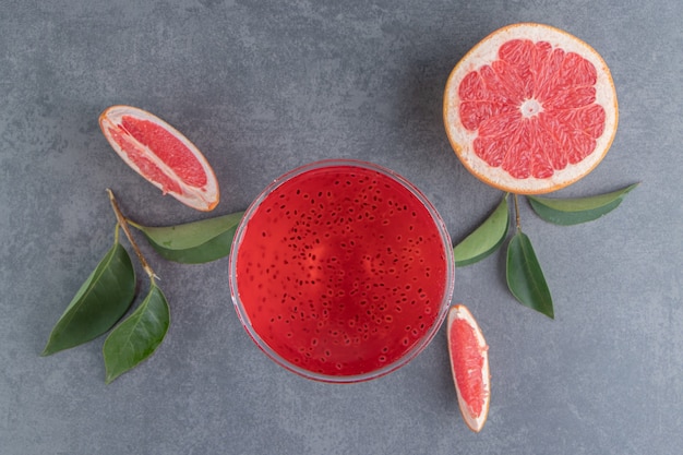 A glass cup with red juice and slices of grapefruit