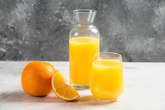 오렌지 조각과 신선한 주스의 유리 컵.