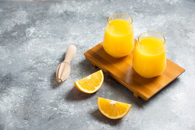 オレンジジュースのガラスカップと木製のリーマー。