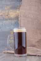 Foto gratuita bicchiere di birra scura sul tavolo di marmo. foto di alta qualità