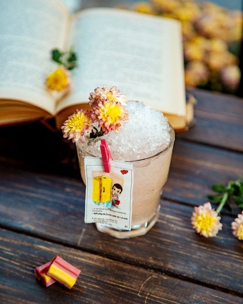 A glass of drink with ice decorated with flowers and liner from love isgum