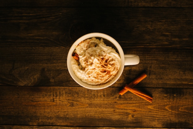 A glass of eggnog shot from above on a wooden surface