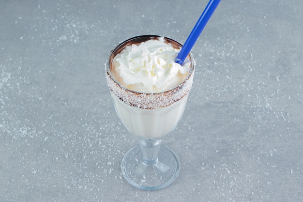 Free photo a glass of flavorful milkshake on the blue background. high quality photo