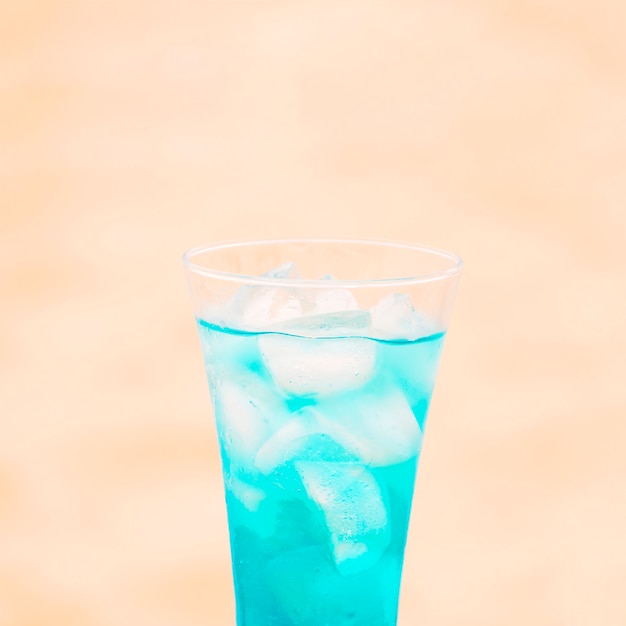 Glass of fresh blue drink with ice cubes