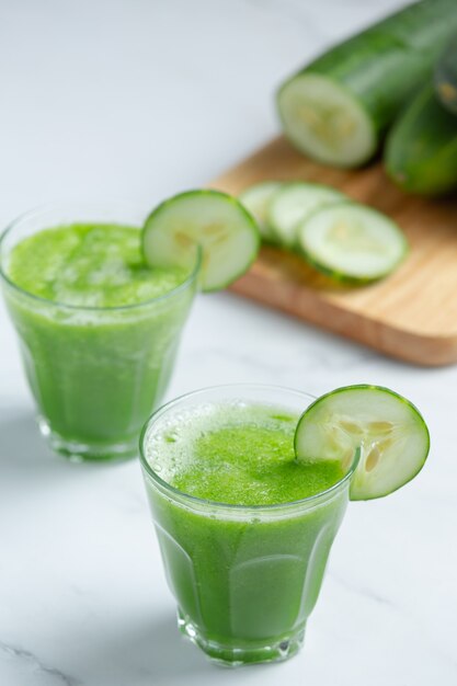 Glass of fresh cucumber juice on marble background