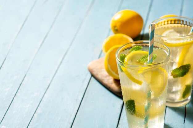 Glass of fresh lemonade on blue wooden table