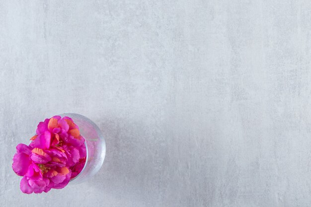 白いテーブルの上に、新鮮な紫色の花のグラス。