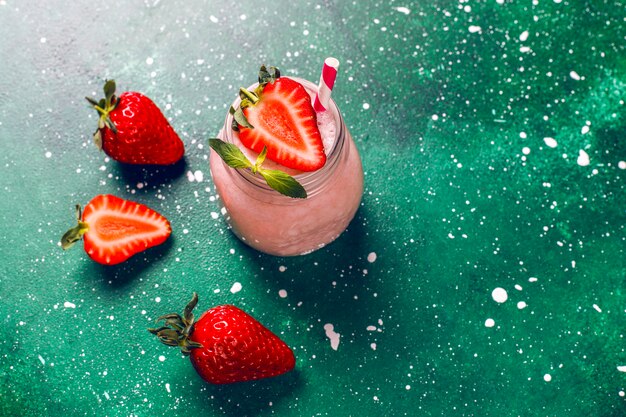 Glass of fresh strawberry milkshake, smoothie and fresh strawberries,healthy food and drink concept.