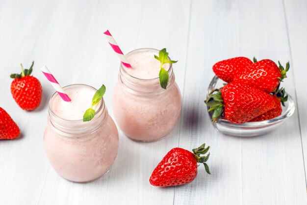 Glass of fresh strawberry milkshake, smoothie and fresh strawberries