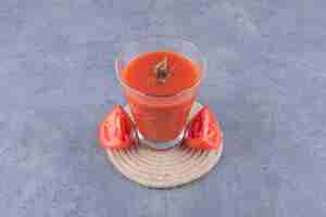 Free photo glass of fresh tomato juice and tomatoes on a wooden board.