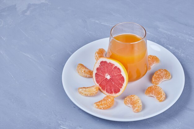 A glass of grapefruit cocktail with fruit salad.