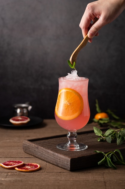 Glass of grapefruit cocktail with an orange slice in it