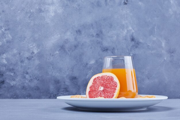 白いプレートにグレープフルーツジュースのグラス。