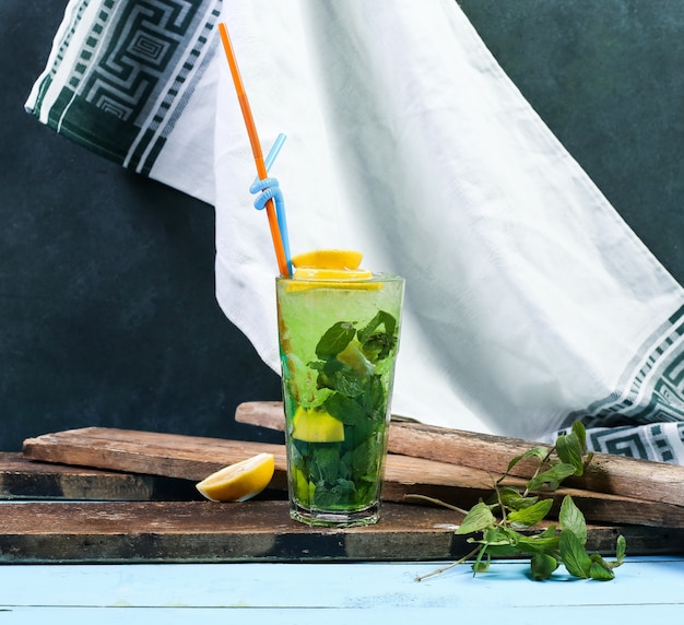 A glass of green mojito with lemon.