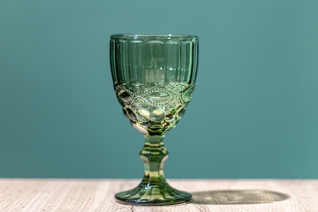 Glass green textured goblet on a blue background