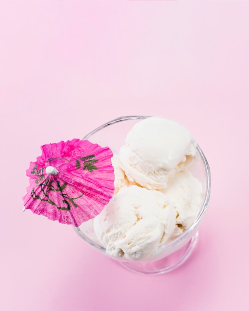 Glass of homemade ice cream with pink umbrella on top