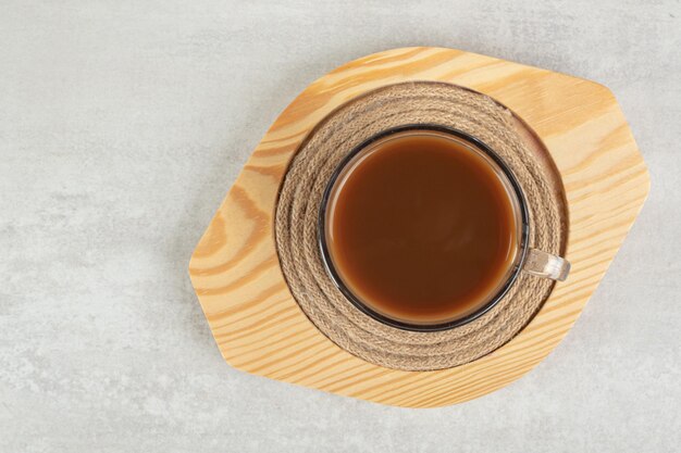 Glass of hot coffee on wooden plate. 
