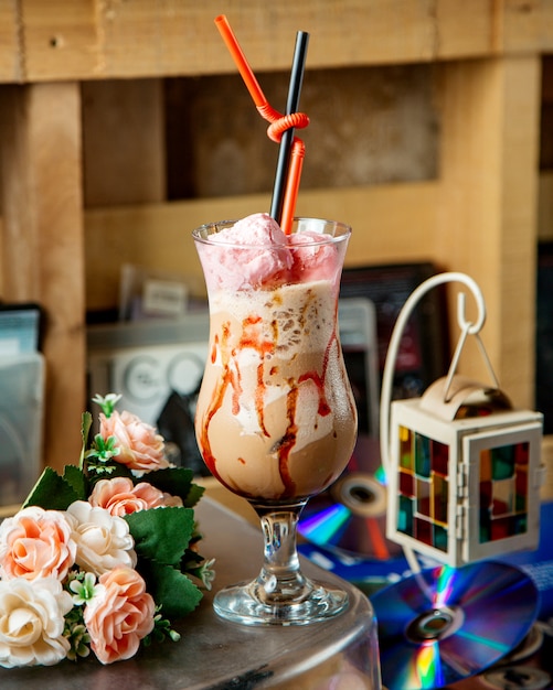 A glass of iced coffee drink garnished with sweet cotton in pink