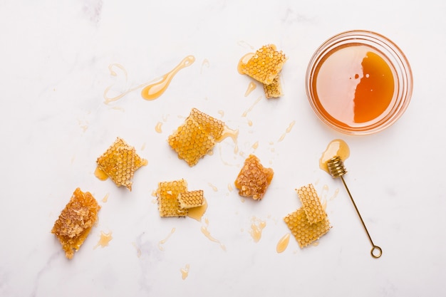 Glass jar full of honey with honey spoon