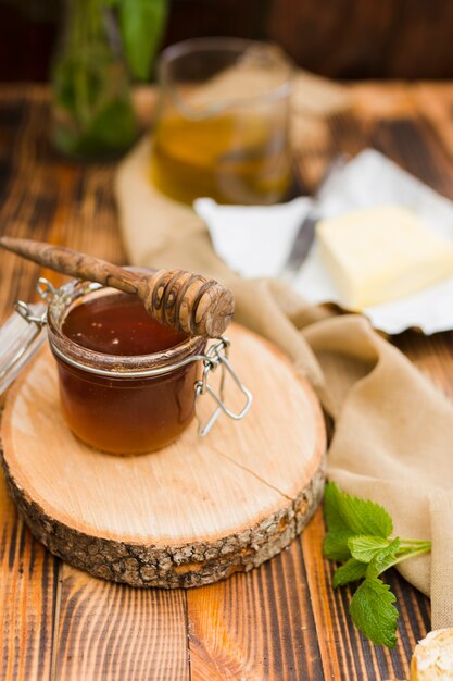 Glass jar full of honey with honey spoon