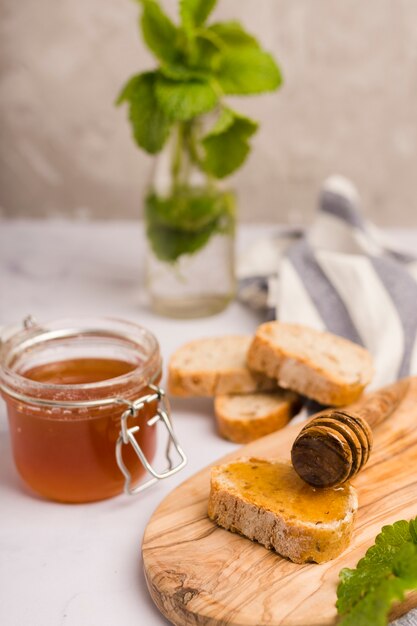 Glass jar full of honey with honey spoon