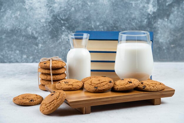 A glass and jar of milk with delicious cookies .