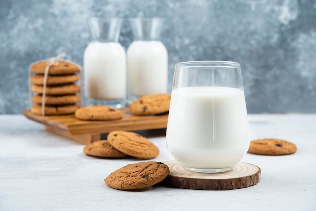 A glass and jar of milk with delicious cookies .