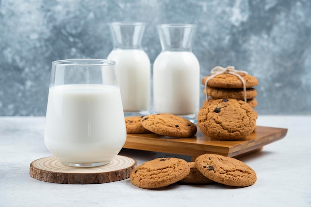 A glass and jar of milk with delicious cookies .