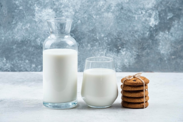 A glass and jar of milk with delicious cookies .