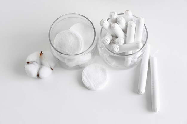 Glass jar with hygienic tampons and cotton flower