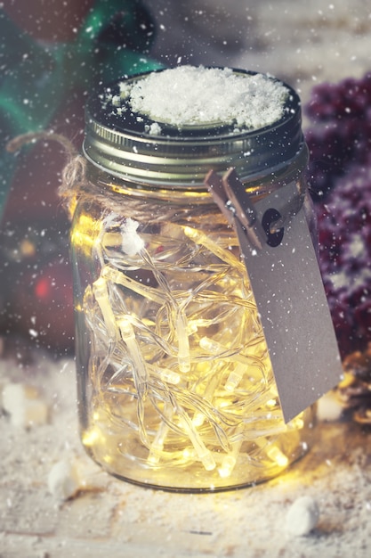 Free photo glass jar with lights and snow on top