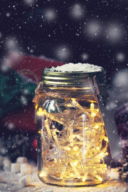 Glass jar with lights and snow on top